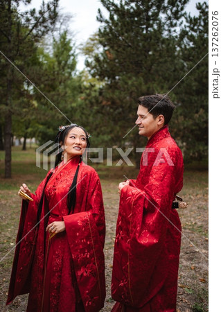 Multicultural couple celebrating traditional Chinese wedding outdoors 137262076