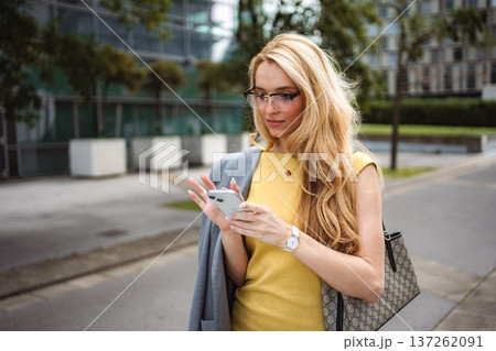 Businesswoman texting on phone in urban city 137262091