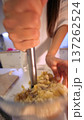 Person prepares mashed potatoes using wooden spoon in home kitchen setting 137262524
