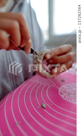 Artisan carefully carves and measures hollow sections in clay 137262564