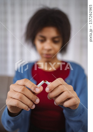 Young woman breaking cigarette and quitting smoking Young woman breaking cigarette and quitting smoking 137262965