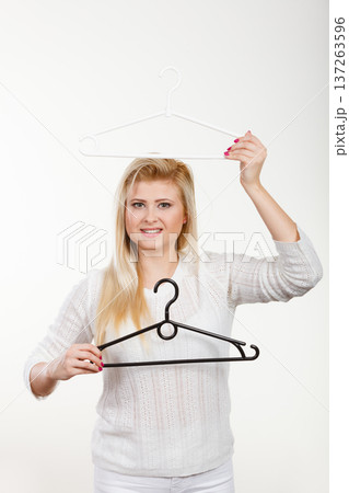 Woman holding clothes hanger Woman holding clothes hanger 137263596