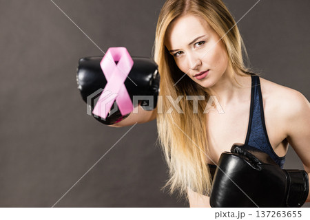 Woman wearing boxing gloves having pink ribbon Woman wearing boxing gloves having pink ribbon 137263655
