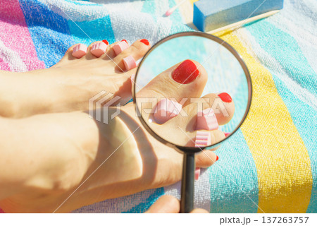 Woman magnifying pedicure Woman magnifying pedicure 137263757