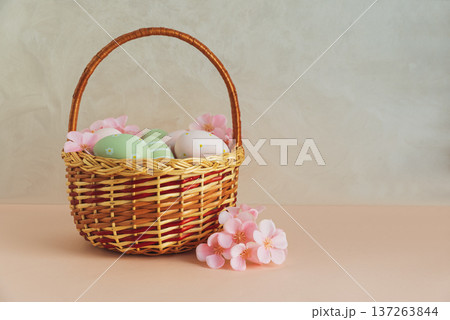 Wicker Easter Basket with Pastel Eggs and Flowers. Soft Spring Decor Wicker Easter Basket with Pastel Eggs and Flowers. Soft Spring Decor 137263844