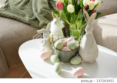 Living Room Decorated Easter Eggs with Bunny Figurines and Tulips. Cozy Spring Holiday Arrangement Living Room Decorated Easter Eggs with Bunny Figurines and Tulips. Cozy Spring Holiday Arrangement 137263851