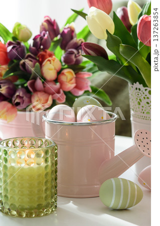 Easter Table with Tulip Bouquets, Eggs, Candles and Festive Decor. Cozy Spring Arrangement Easter Table with Tulip Bouquets, Eggs, Candles and Festive Decor. Cozy Spring Arrangement 137263854