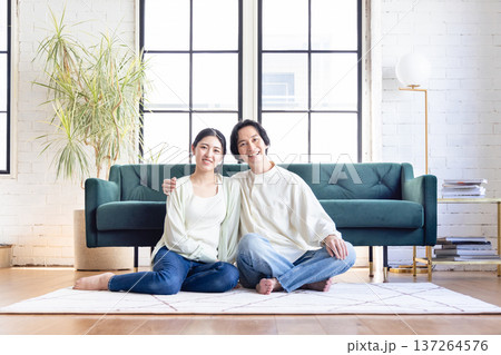リビングでくつろぐ若い夫婦 リビングでくつろぐ若い夫婦 137264576