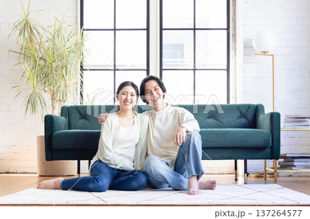 リビングでくつろぐ若い夫婦 リビングでくつろぐ若い夫婦 137264577