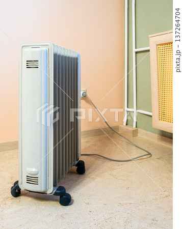 side view of oil-filled electric heater in room side view of oil-filled electric heater in room 137264704