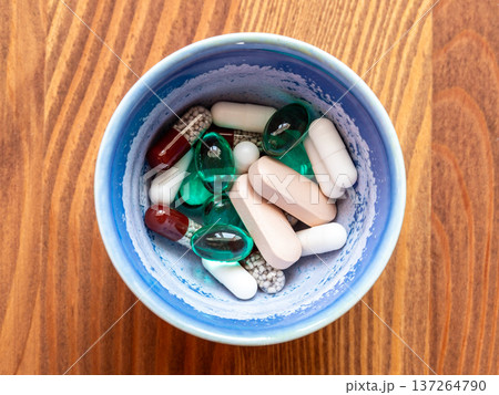 many various pills in ceramic bowl on wooden table many various pills in ceramic bowl on wooden table 137264790