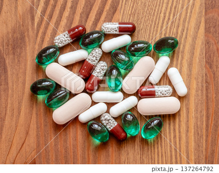 many different pills on wooden table closeup 137264792