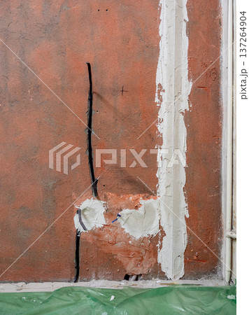 wall with electrical sockets covered with plaster 137264904