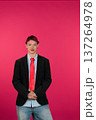 Young person posing confidently wearing blazer and red tie 137264978