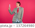 Person taking selfie with smartphone on pink background 137264980