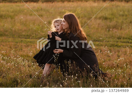 Gentle Mother Guides Young Girl Through Blooming Wildflowers In Bright Meadow Setting Gentle Mother Guides Young Girl Through Blooming Wildflowers In Bright Meadow Setting 137264989