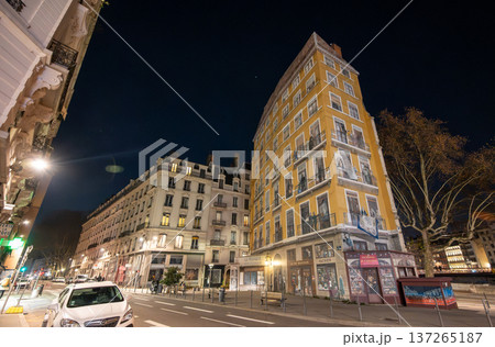 Lyon, france. December 27, 2023. Building showing a large trompe-l'oeil mural depicting historical figures and scenes on an illuminated street during night 137265187