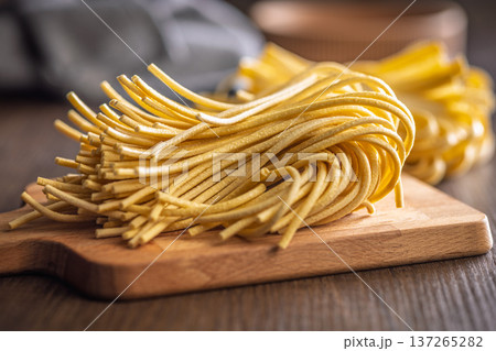 Fresh pasta ready for cooking, showing strands of bigoli set on a wooden background 137265282