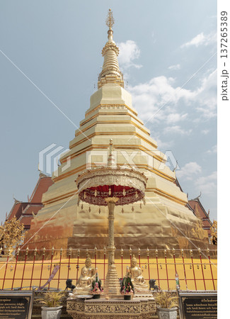 The centerpiece of the ancient Wat Phra That Cho Hae is its imposing Chiang Saen-style pagoda. Characterized by a broad square base and tiered golden surfaces, the structure tapers into a slender The centerpiece of the ancient Wat Phra That Cho Hae is its imposing Chiang Saen-style pagoda. Characterized by a broad square base and tiered golden surfaces, the structure tapers into a slender 137265389