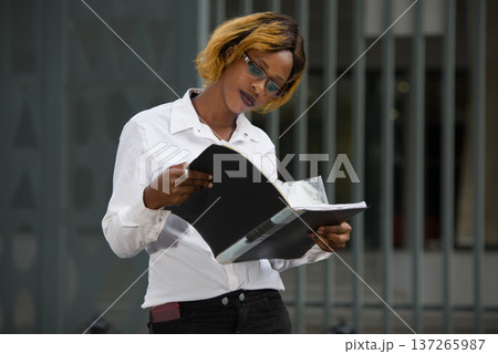 Beautiful girl in casual clothes reading outside Beautiful girl in casual clothes reading outside 137265987