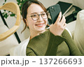自宅のソファーでスマホを見る女性 137266693