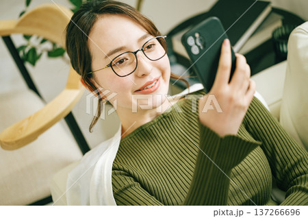 お家のソファーでスマホを見る女性 お家のソファーでスマホを見る女性 137266696