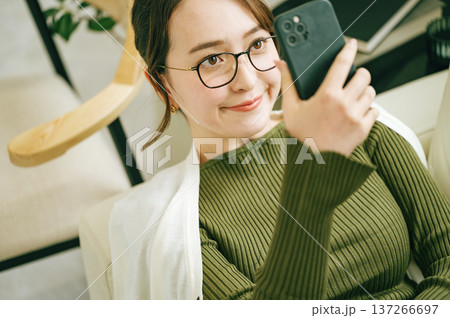 お家のソファーでスマホを見る女性 137266697