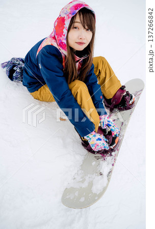 冬にゲレンデでスノーボードを楽しむ若い女性 137266842