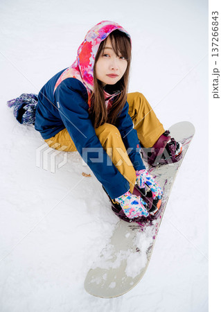 冬にゲレンデでスノーボードを楽しむ若い女性 137266843