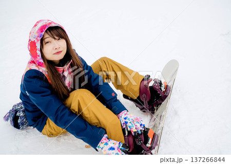 冬にゲレンデでスノーボードを楽しむ若い女性 冬にゲレンデでスノーボードを楽しむ若い女性 137266844