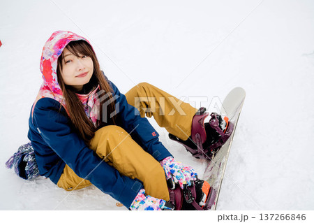 冬にゲレンデでスノーボードを楽しむ若い女性 137266846