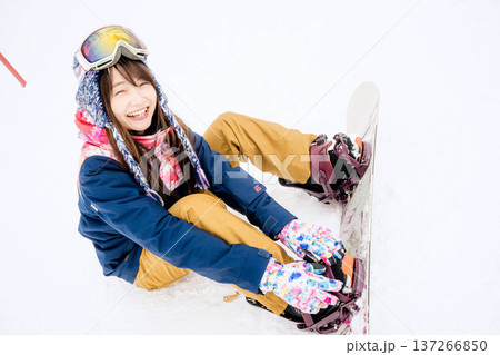 冬にゲレンデでスノーボードを楽しむ若い女性 137266850