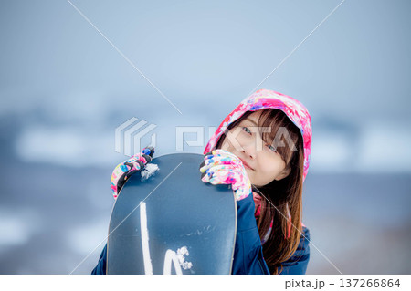 冬にゲレンデでスノーボードを楽しむ若い女性 冬にゲレンデでスノーボードを楽しむ若い女性 137266864