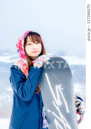 冬にゲレンデでスノーボードを楽しむ若い女性 冬にゲレンデでスノーボードを楽しむ若い女性 137266870