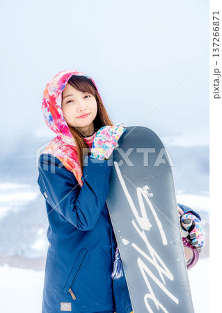 冬にゲレンデでスノーボードを楽しむ若い女性 冬にゲレンデでスノーボードを楽しむ若い女性 137266871