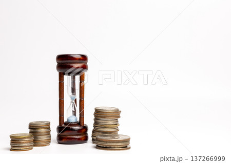白背景に砂時計と積み上げた硬貨 白背景に砂時計と積み上げた硬貨 137266999