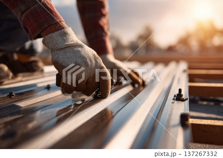 Close-Up of Hands Fixing Roof Panels with Tools and Protective Gloves 137267332