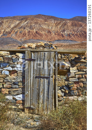 Abandoned Stone Building Wooden Door and Mountain Landscape in Death Valley 137268191