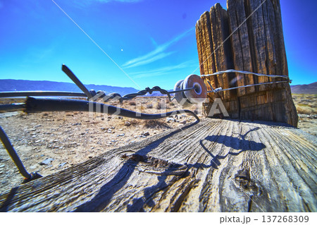 Barbed Wire Fence Post and Ceramic Insulator in California Desert Landscape 137268309