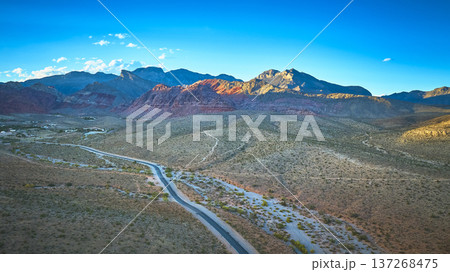 Aerial Red Rock Canyon Desert Road and Turtlehead Peak Under Clear Blue Sky Aerial Red Rock Canyon Desert Road and Turtlehead Peak Under Clear Blue Sky 137268475
