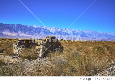Abandoned Stone Structure Desert Brush and Mountains Under Clear Blue Sky 137268481
