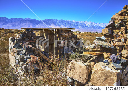 Abandoned Stone Structure in California Desert with Mountain Range in Bright Sunlight 137268485