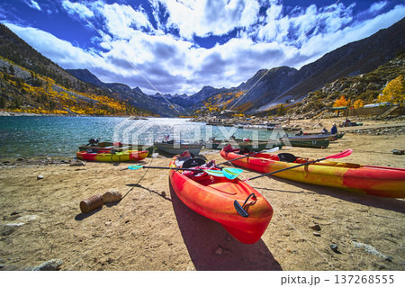 Kayaks Boats and Mountain Lake Shoreline with Fall Colors and Dramatic Clouds Kayaks Boats and Mountain Lake Shoreline with Fall Colors and Dramatic Clouds 137268555