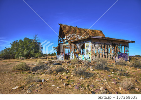 Abandoned Graffiti Covered Building in Desert Landscape Under Blue Sky 137268635