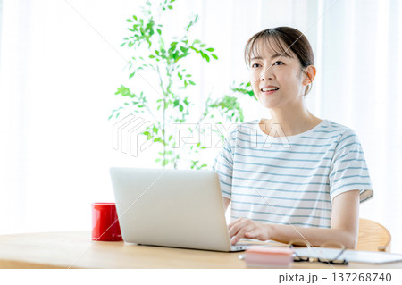リビングでパソコンを使う若い女性 リビングでパソコンを使う若い女性 137268740