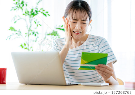 通帳を見てため息をつく主婦 通帳を見てため息をつく主婦 137268765