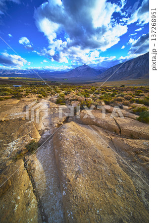 Rocky Wagon Trail Leading to Dramatic Mountain Landscape Under Vibrant Sky 137268951