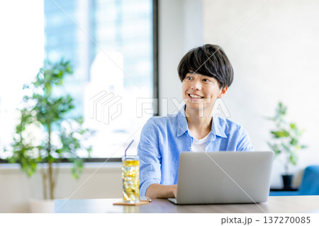 カフェで作業をする若い男性 137270085