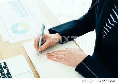 デスクでメモをとるビジネスウーマン デスクでメモをとるビジネスウーマン 137271358