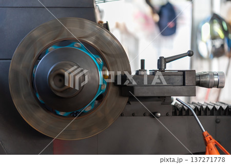Industrial metal lathe machine rotating steel disc during machining process in workshop Precision engineering equipment used for manufacturing mechanical parts and metalworking industry 137271778